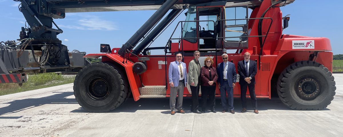 Canadian Consulate standing outside in the afternoon with various members of Iron Horse with a crane behind them